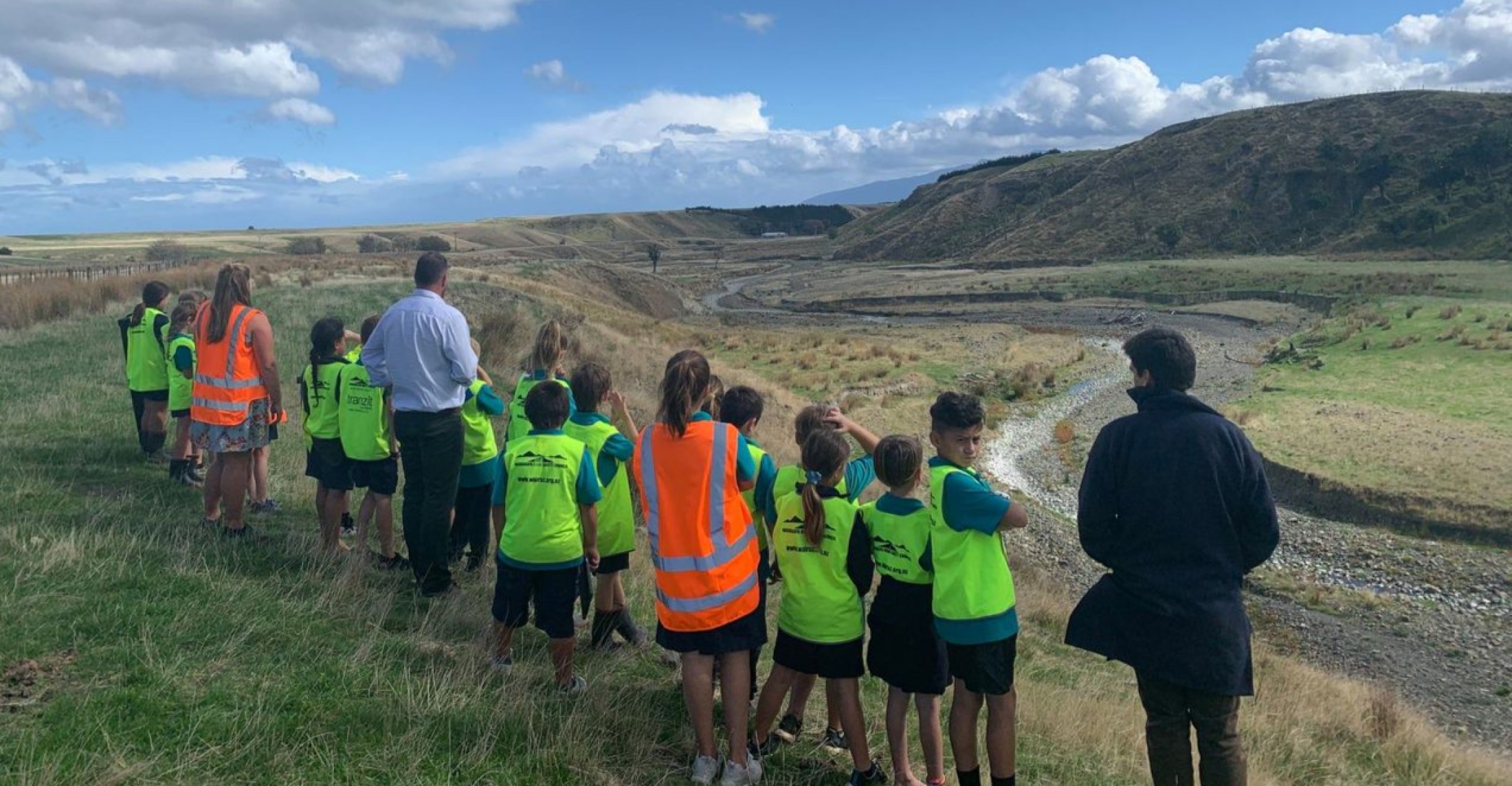 Student scientists from Pirinoa School look down on a stream on Palliser Ridge Station