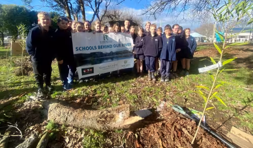 Solway primary School pupils holding a "Schools Behind Our River" banner